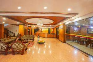 a living room with furniture and a bowling alley at Hotel Indraprastha Thiruvalla in Talavadi