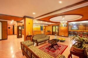 a living room with a couch and a table at Hotel Indraprastha Thiruvalla in Talavadi