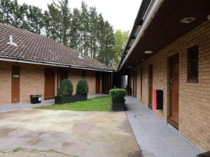 a courtyard of a brick building with two bushes at Stay Inn Express, Cambridge in Cambridge