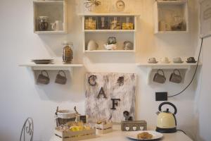 a kitchen with white shelves and a counter with a tea kettle at Elegant B&B - Il Vicolo storico in Salerno