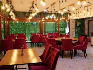 a restaurant with wooden tables and red chairs at Stay Inn Express, Cambridge in Cambridge
