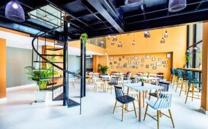 a restaurant with tables and chairs and a staircase at Therizinpattaya in Pattaya South