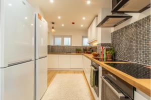 a kitchen with white cabinets and a refrigerator at 6 En-Suites with 7 Beds Near Arena & City in Nottingham