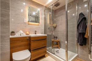 a bathroom with a shower and a toilet and a sink at 6 En-Suites with 7 Beds Near Arena & City in Nottingham +34 photos