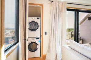 a laundry room with a washer and dryer next to a window at Offshore Spa & Residences in Montauk