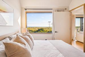 a bedroom with a bed and a large window at Offshore Spa & Residences in Montauk +3 photos