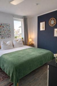 a bedroom with a large bed with a green blanket at Ferienwohnung 125 qm für 6 Gäste im Zentrum Heinsberg in Heinsberg +5 photos
