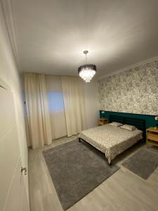 a bedroom with a bed and a chandelier at The Pearl Suite - your stylish cozy and modern flat,in the heart of South Tenerife,just 3 minutes from beach and natural pools in Alcalá