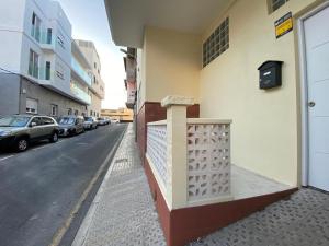 a building with a fence on the side of a street at The Pearl Suite - your stylish cozy and modern flat,in the heart of South Tenerife,just 3 minutes from beach and natural pools in Alcalá