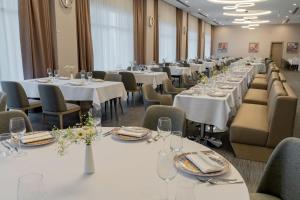 a row of tables in a room with white tables and chairs at Yevlakh City Hotel in Yevlax