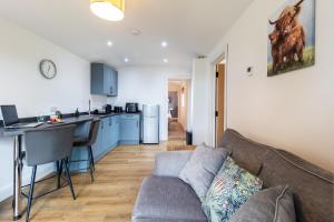 a living room with a couch and a kitchen at The Calf House in Sibbertoft +7 photos