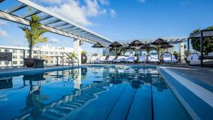 a pool at a hotel with chairs and umbrellas at Angler's Hotel - Miami Beach in Miami Beach