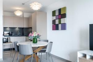 a kitchen and dining room with a white table and chairs at Victoria Palace- l'appartement avec vue mer et à proximité de Monaco in Beausoleil +7 photos