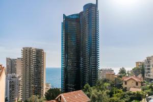 a view of a city with tall buildings and the ocean at Victoria Palace- l'appartement avec vue mer et à proximité de Monaco in Beausoleil