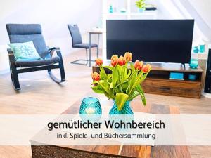 a vase of flowers on a table in a living room at strandnah & ruhig für 4 Pers in Bensersiel
