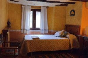 a bedroom with a large bed with a window at Casa Rural El Ensueño in Caneto