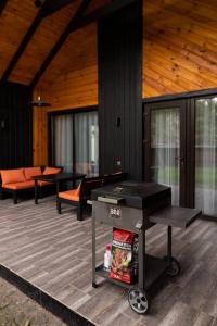a screened in porch with a grill on a deck at Chudodiyevo Park- Hotel in Vyshpolʼ