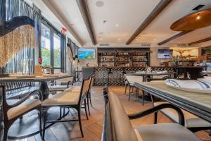 a restaurant with tables and chairs and a library at Angler's Hotel - Miami Beach in Miami Beach