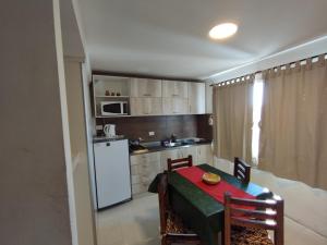 a kitchen with a table and a small kitchen with a white refrigerator at Complejo EyE in General Roca