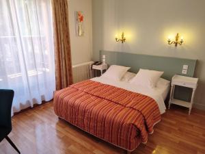 a bedroom with a large bed with a red blanket at l'Auberge des Gourmets Hôtel Restaurant in Le Vaudioux