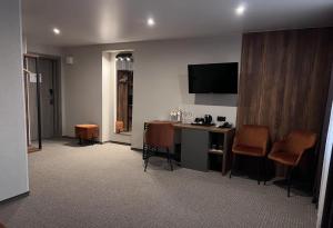 a hotel room with a desk and a television at Optima Collection River Park in Lutsk