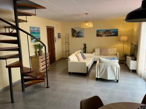 a living room with a couch and a staircase at Close to the beach duplex in Tossa de Mar