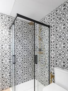 a bathroom with a black and white patterned wall at El Sueño, Pilaro in Barres