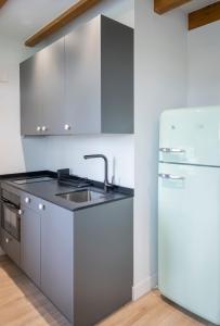 a kitchen with a sink and a refrigerator at El Sueño, Pilaro in Barres +3 photos