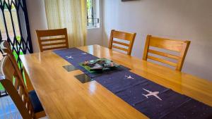 a dining room table with chairs and a wooden table with an airplane on it at The Aviators Villa in Flic-en-Flac