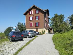 two cars parked in front of a building at Gemütliche Wohnung im Grünen in Herisau