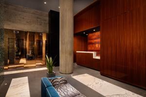 a lobby with a blue couch and a column at Hotel Hendricks in New York +35 photos