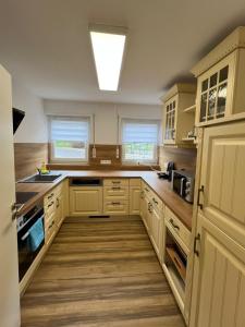 a large kitchen with white cabinets and wooden floors at Schwarzwald Loft in Villingen-Schwenningen