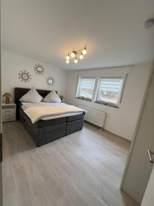 a bedroom with a bed and two windows at Schwarzwald Loft in Villingen-Schwenningen