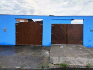 a blue building with two garage doors at Microcasa espaçosa e acolhedora in Caraguatatuba