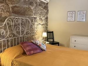 a bedroom with a bed with a stone wall at Serena Nest 02 in Cabeceiras de Basto
