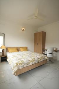 a bedroom with a bed and a desk and a chair at HomeSlice Sarjapur - Balcony Rooms in Bangalore