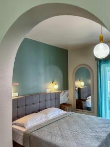 ein Schlafzimmer mit einem großen Bett und einem großen Spiegel in der Unterkunft Jolly Pad Deluxe Studio - 5 min walk to Tsilivi Beach in Planos