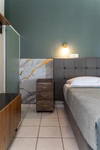 ein Schlafzimmer mit einem Bett, einer Kommode und einem Nachttisch in der Unterkunft Jolly Pad Deluxe Studio - 5 min walk to Tsilivi Beach in Planos