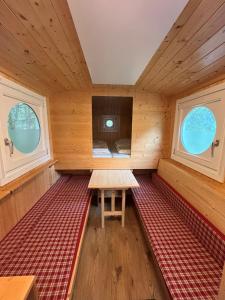 a room with a bench in a cabin with two windows at NATURAMA Brombachsee Schäferwagenhotel in Pleinfeld
