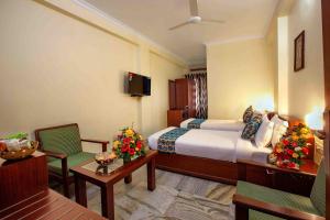 a hotel room with a bed and a table and chairs at Hotel Indraprastha Karunagapally in Panmana +22 photos