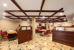 a dining room with red chairs and tables in it at Hotel Indraprastha Karunagapally in Panmana