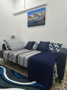 a bedroom with a bed and a painting on the wall at Coral Reef Charming studio by the three old cities in Cospicua
