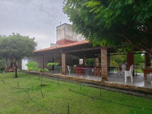 a house with a patio with tables and chairs at Casa em condominio com piscina na beira do rio Alegre in Santo Amaro