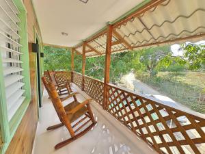 two rocking chairs on a porch with a view of a street at Casa Mar y Campo in San Felipe de Puerto Plata