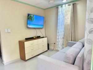 a living room with a couch and a tv on the wall at Casa Mar y Campo in San Felipe de Puerto Plata