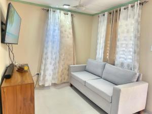 a living room with a couch and a television at Casa Mar y Campo in San Felipe de Puerto Plata +3 photos