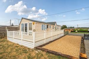 a tiny house with a white fence at Washington Lodge in Heacham