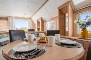 a dining room with a wooden table and chairs at Washington Lodge in Heacham +10 photos