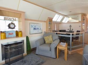 a living room with a chair and a fireplace at Washington Lodge in Heacham