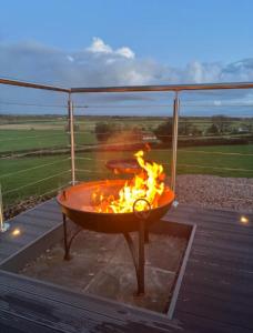 a fire pit on a deck with flames in it at Caerlaverock Glamping - Sycamore in Dumfries